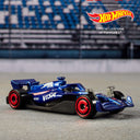 Blue Formula 1 die-cast car with red wheels from the Hot Wheels 5-pack on a racetrack backdrop