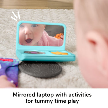 Baby looking into the mirrored pretend laptop during tummy time