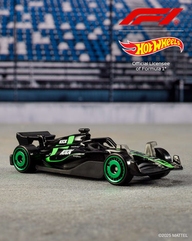 Black and green Formula 1 die-cast car from the Hot Wheels 5-pack on a racetrack backdrop