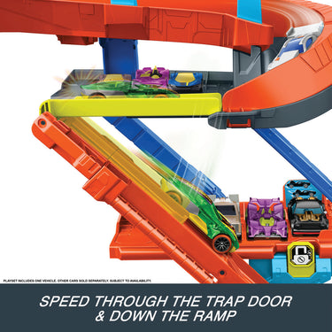 Toy car speeding through the trap door and down the ramp of the Hot Wheels stunt garage