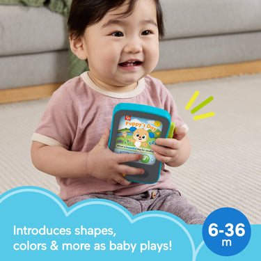 Smiling baby holding the Puppy's Storytime Reader toy