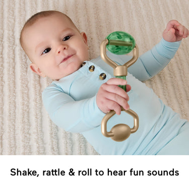 Baby holding the rattle face roller toy from the Mini Me Moments set
