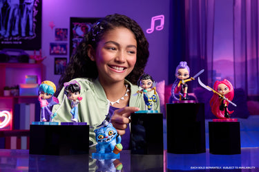 Smiling girl displaying KPop Demon Hunters collectible figures on stands