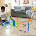 Child playing with the Hot Wheels Rapid Launch & Loop playset on a living room floor