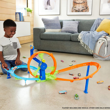 Child playing with the Hot Wheels Rapid Launch & Loop playset on a living room floor