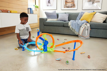 Child playing with the Hot Wheels Rapid Launch & Loop playset on a living room floor