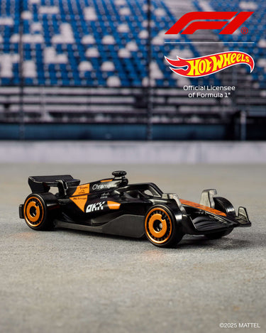 Black and orange Formula 1 die-cast car from the Hot Wheels 5-pack on a racetrack backdrop