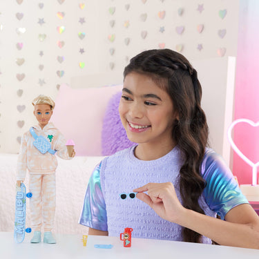 Child playing with the Barbie Dream Besties Ken doll and his sunglasses and accessories