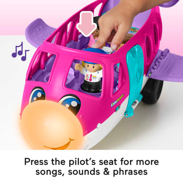 Hand pressing the pilot figure into the cockpit seat of the Barbie Little Dream Plane