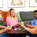 Four players around a coffee table playing UNO Teams in pairs
