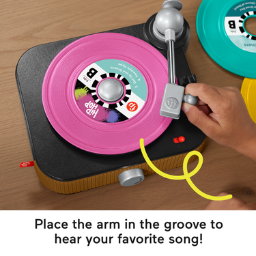 Hand placing the arm on a pink record on the toy turntable