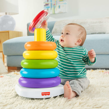 Baby sitting beside the stacked Fisher-Price Giant Rock-a-Stack