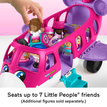 Hand placing a Little People figure into a seat on the Barbie Little Dream Plane filled with figures