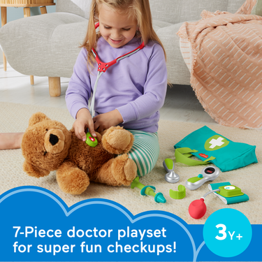 Girl giving a teddy bear a checkup with the Fisher-Price Medical Kit