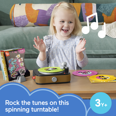 Girl clapping beside the Rockin' Record Player toy on a table